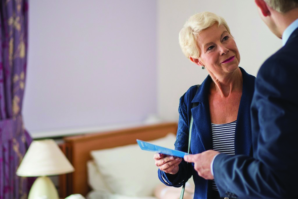 Woman looking at someone else holding a leaflet