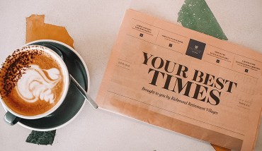 Pink newspaper on brightly coloured table with coffee 