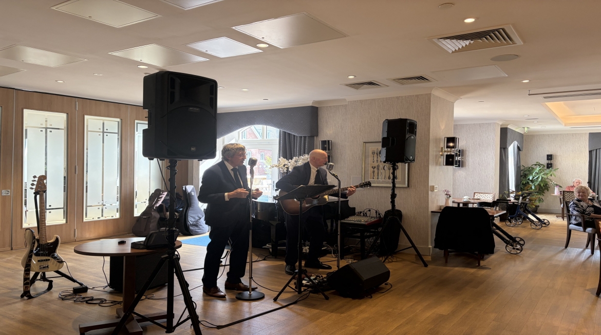 Two men playing instruments and singing