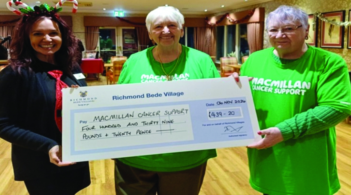 Three people holding a large cheque