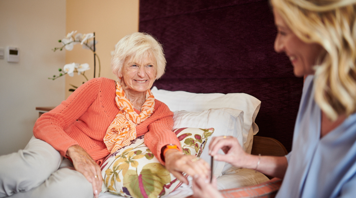 A lady sat on a bed smiling