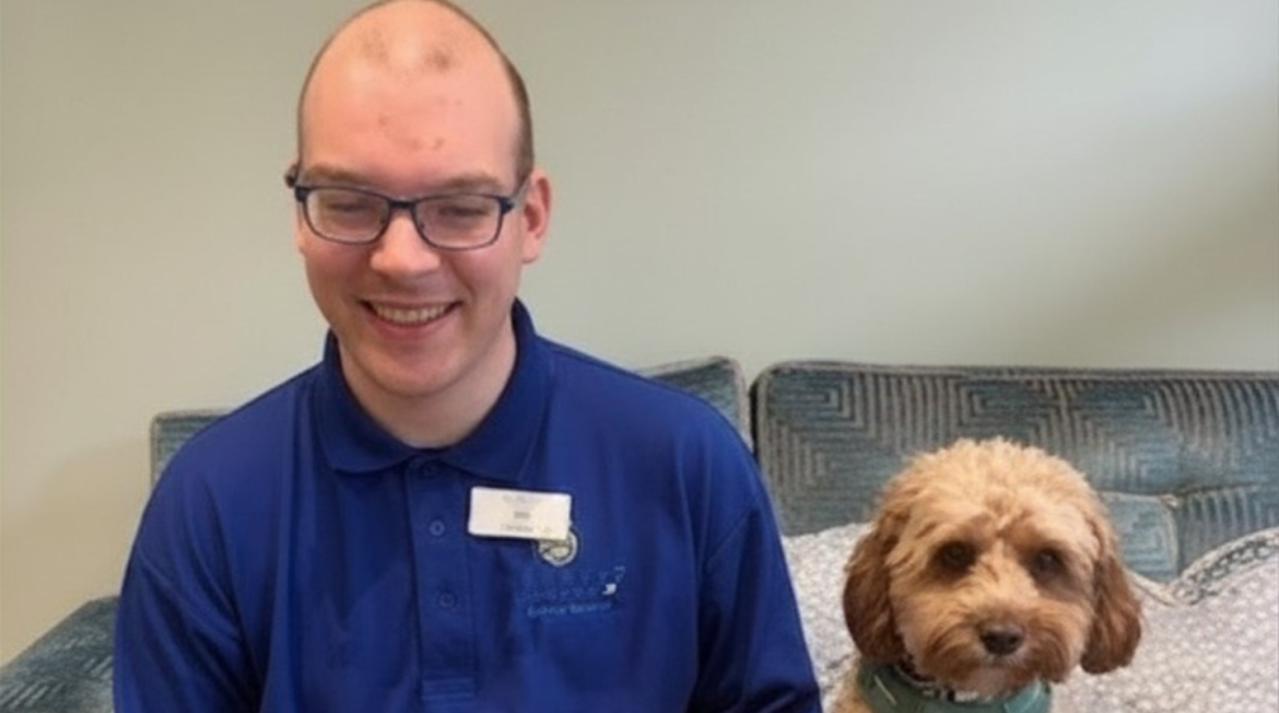 A man and a dog sitting on a sofa