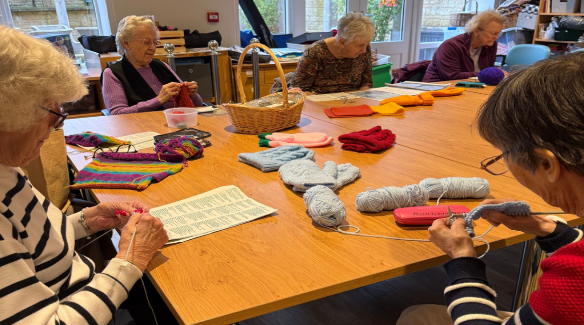 Ladies knitting around a table