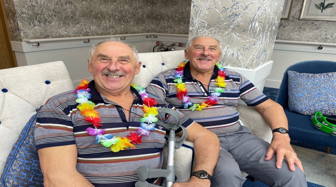 Two people sat on chairs smiling