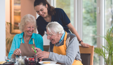 Carer with two elderly people laughing