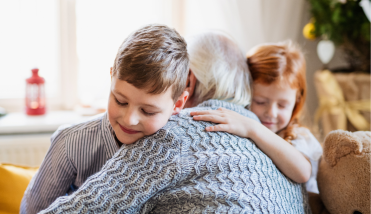 Grandmother hugging two grandchildren