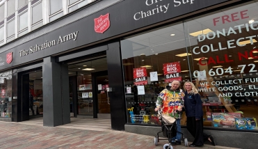 Two people standing outside the Salvation Army Shop