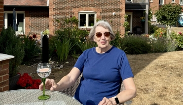 Resident sitting at table with a drink
