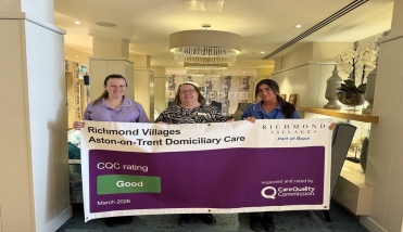 Three people holding a banner