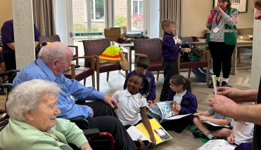 People sat in a room with chairs and books