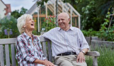 Two people set on a bench laughing