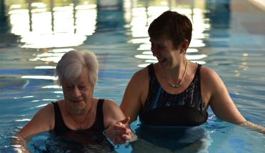 ELDERLY LADY IN SWIMMING POOL WITH SWIM INSTRUCTOR