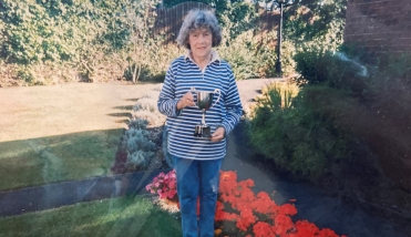 FEMALE RESIDENT SURROUNDED BY BEAUTIFUL GARDEN